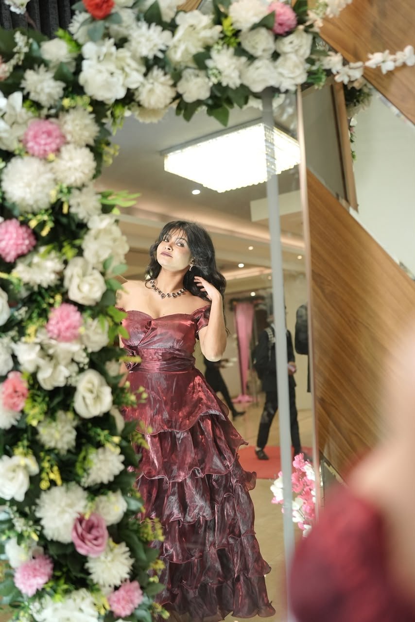 Vaishnavi Kadekar in a maroon tiered gown reflected in a flower-framed mirror
