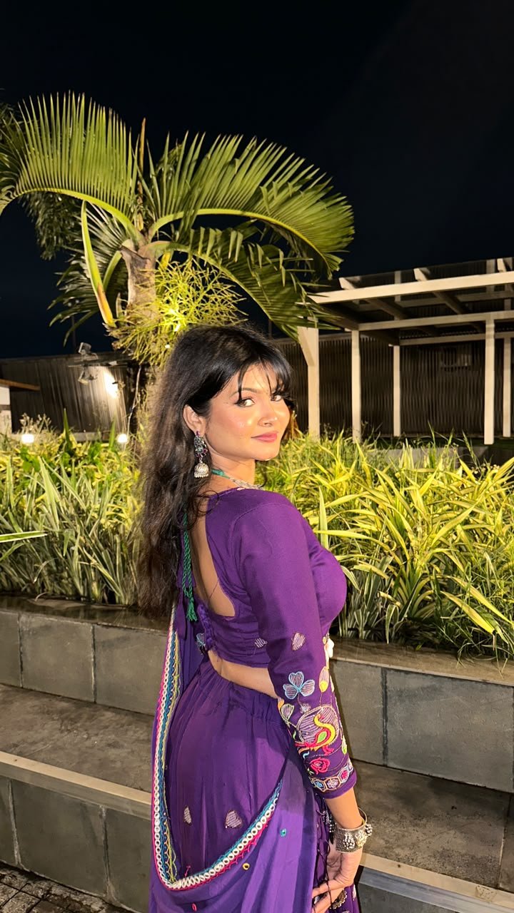 Vaishnavi Kadekar in a purple embroidered saree in a garden at night